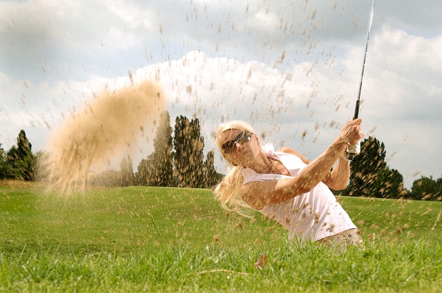 woman golfer splashing out of the bunker