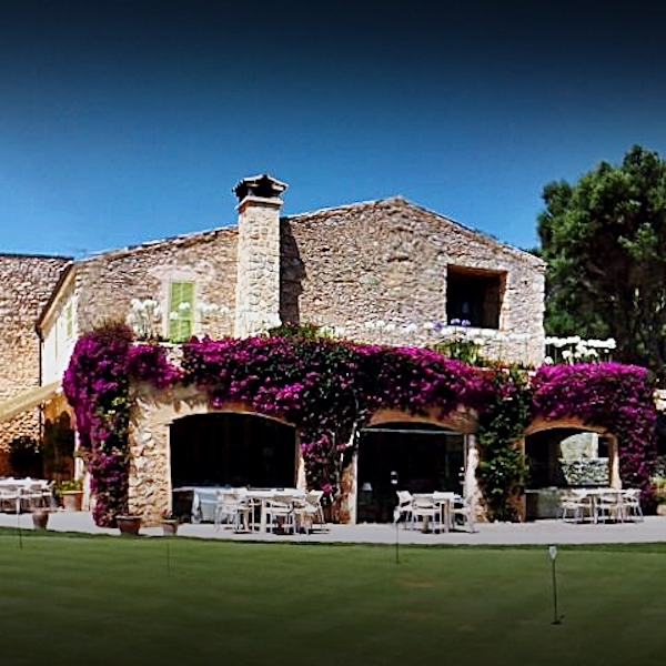 Historic Pula Golf Hotel surrounded by bougainvillea with putting green in foreground