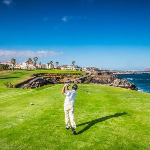 Golfer shoots for the green over water on Amarilla Golf, Tenerife