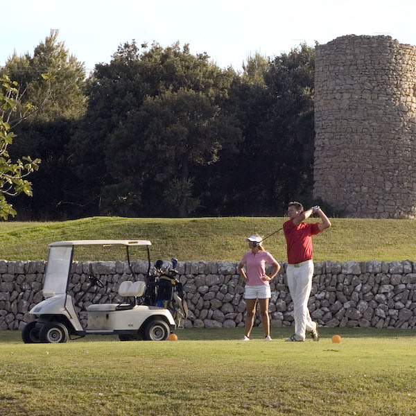 Couple golfing with a buggy at Capdepera Golf, Mallorca